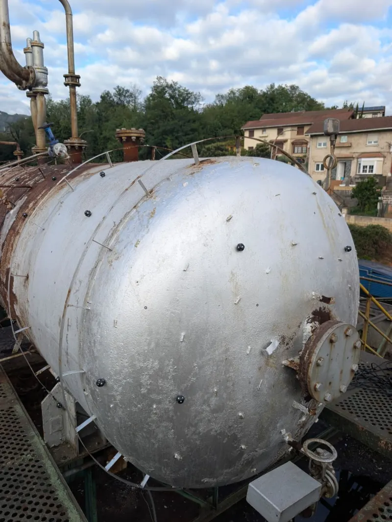 Deposito industrial zilindriko bat fabrika baten estalkian, eskaneatze-markekin (dianak) metalezko gainazalean itsatsita